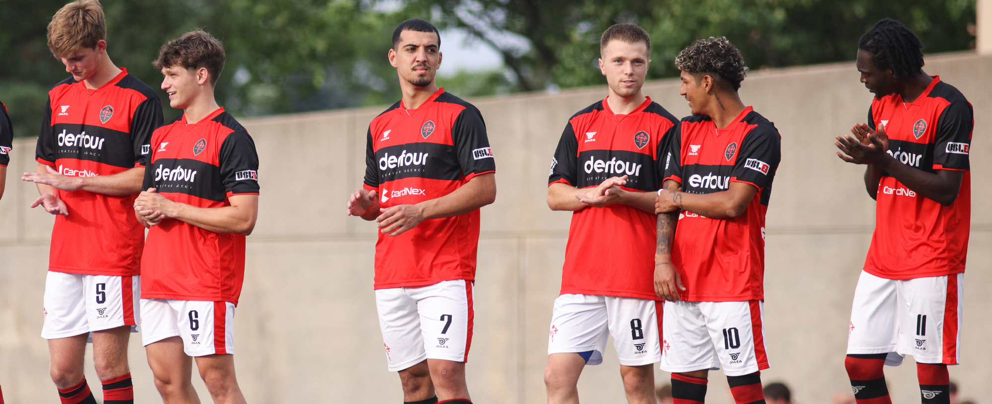 Team players in red and black uniforms on field